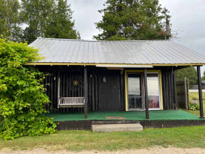 Cabin with a green carpeted front porch