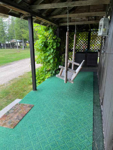 Front porch of a cabin with a wooden swing